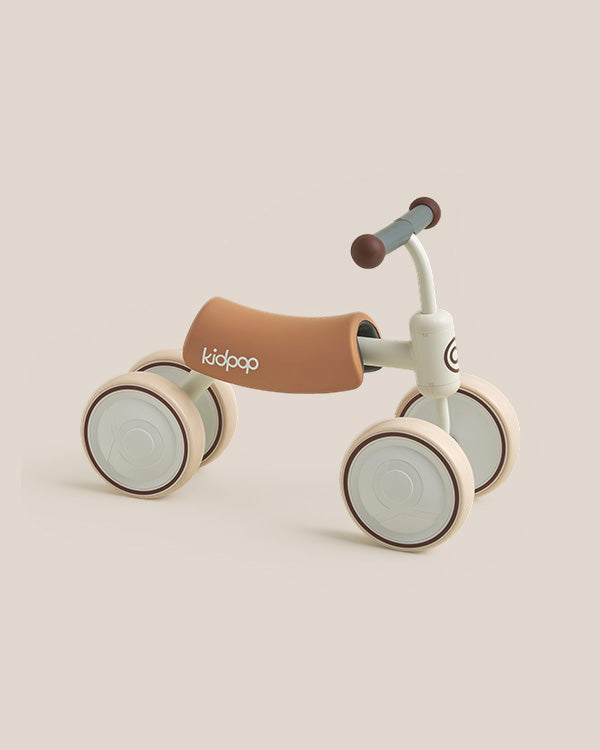 BIG BEE Baby Balance Bike, four-wheel ride-on with tan seat and cream frame, Kidpop logo on seat.