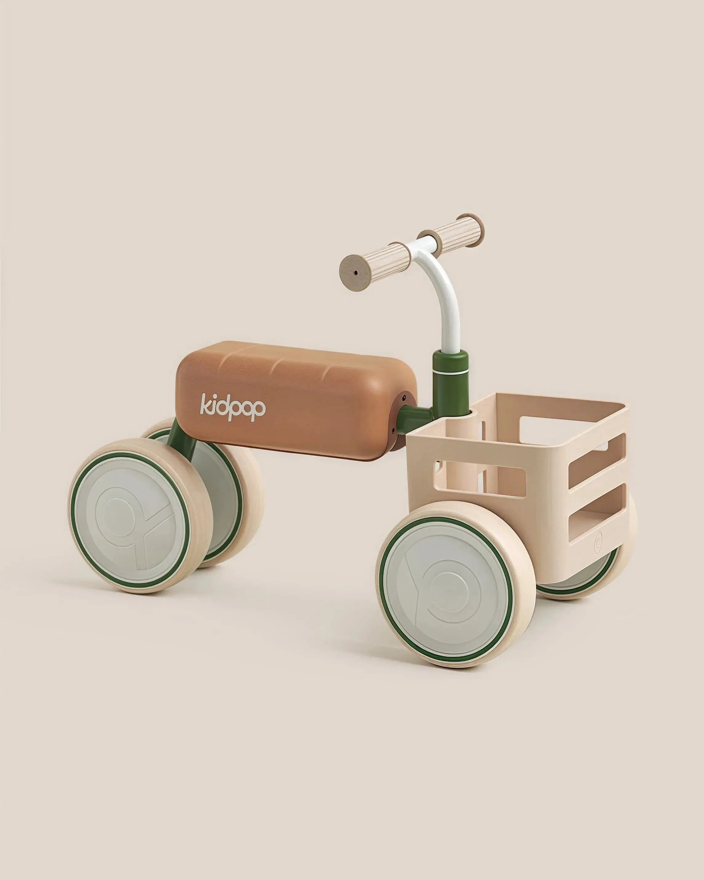 TOAST Baby Balance Bike with brown seat, beige frame, light green wheels and storage basket, product appearance.