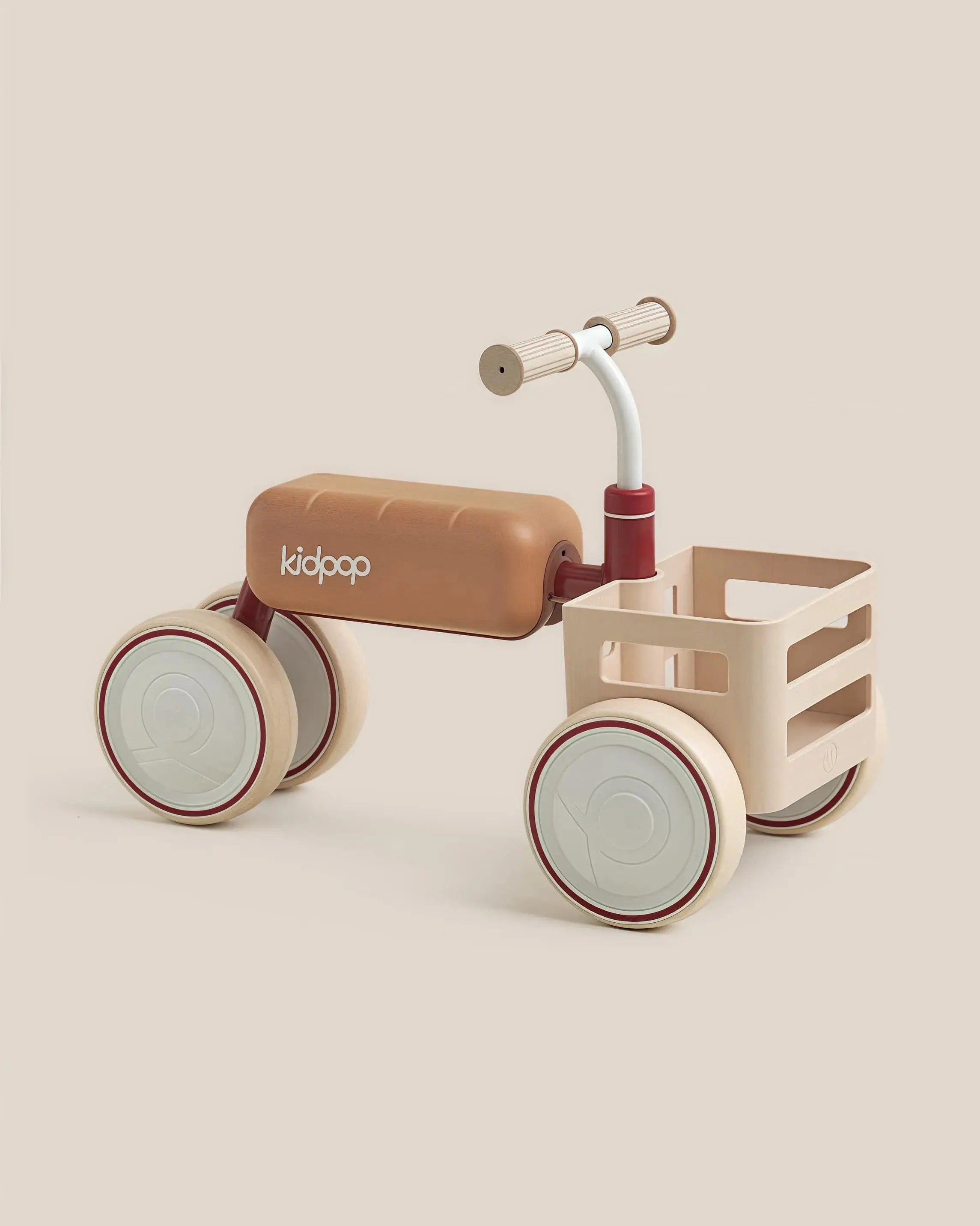 TOAST Baby Balance Bike with tan seat, red accents, cream wheels & basket. Kidpop logo visible. Product appearance.